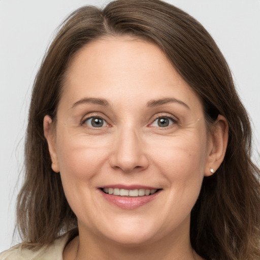 Joyful white adult female with long  brown hair and grey eyes