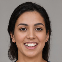 Joyful latino young-adult female with medium  brown hair and brown eyes