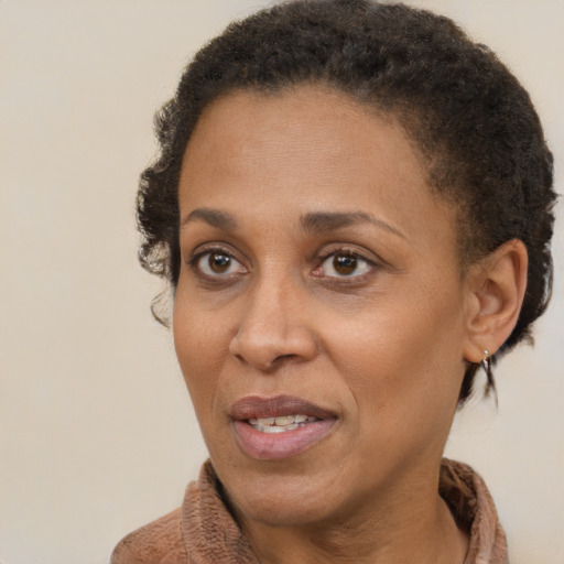 Joyful black adult female with short  brown hair and brown eyes