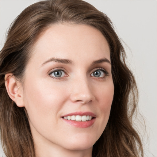 Joyful white young-adult female with long  brown hair and blue eyes