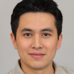 Joyful asian young-adult male with short  brown hair and brown eyes