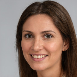 Joyful white young-adult female with long  brown hair and green eyes