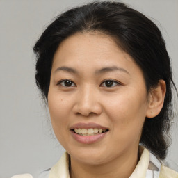 Joyful asian young-adult female with medium  brown hair and brown eyes