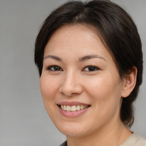 Joyful asian young-adult female with medium  brown hair and brown eyes