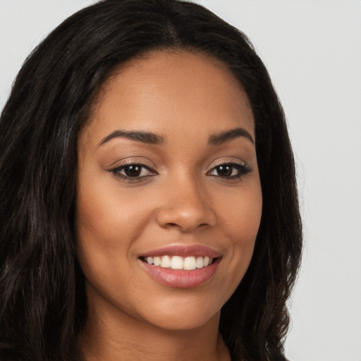 Joyful latino young-adult female with long  brown hair and brown eyes