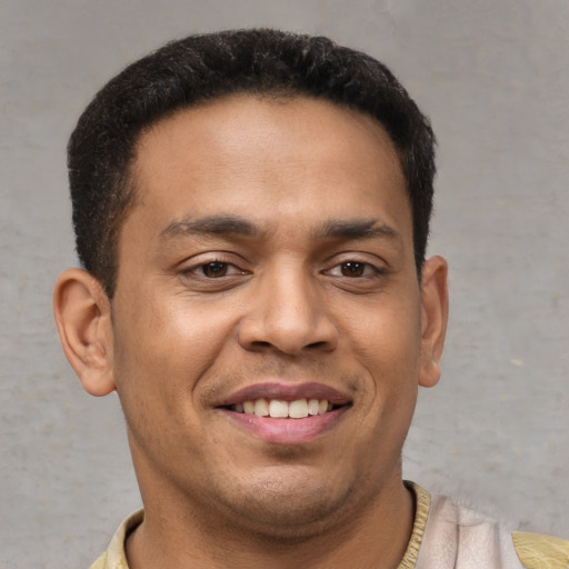 Joyful latino young-adult male with short  brown hair and brown eyes