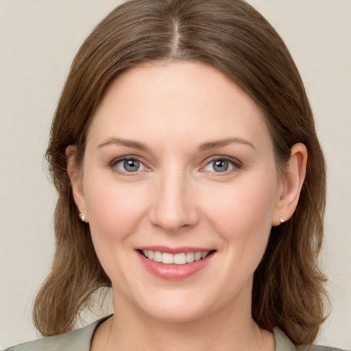 Joyful white young-adult female with medium  brown hair and grey eyes