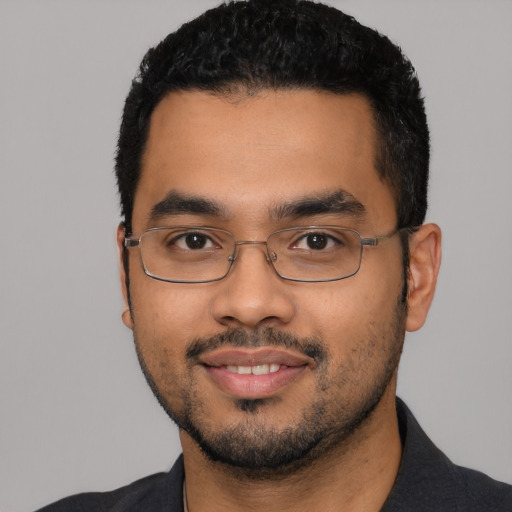 Joyful latino young-adult male with short  black hair and brown eyes