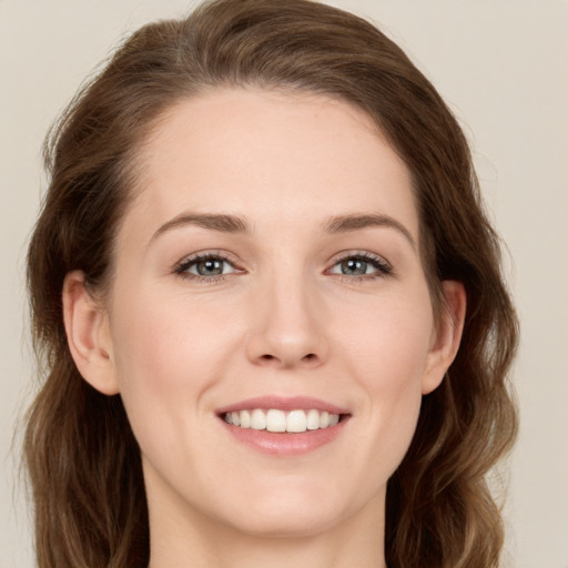 Joyful white young-adult female with long  brown hair and green eyes