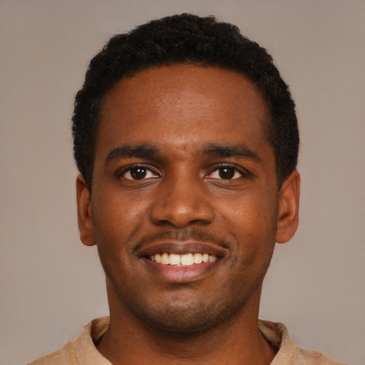 Joyful black young-adult male with short  black hair and brown eyes