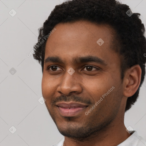 Joyful black young-adult male with short  black hair and brown eyes