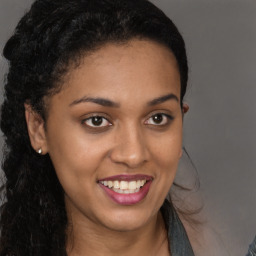 Joyful black young-adult female with long  brown hair and brown eyes