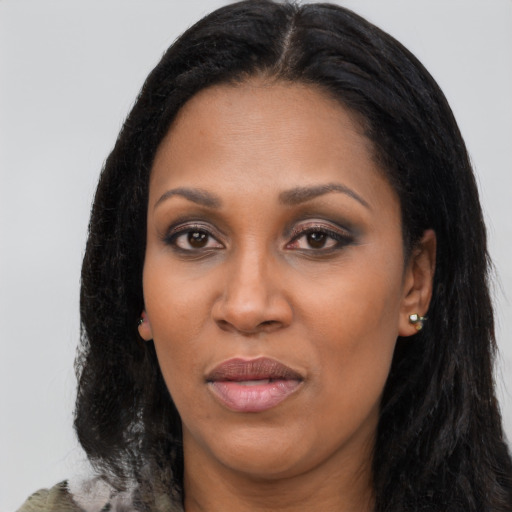 Joyful black young-adult female with long  black hair and brown eyes