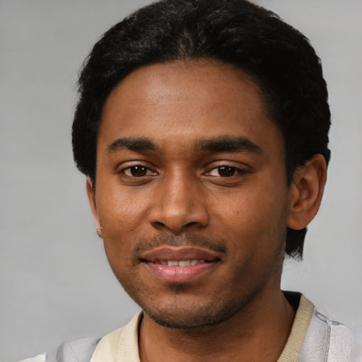 Joyful black young-adult male with short  black hair and brown eyes