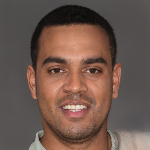 Joyful black young-adult male with short  brown hair and brown eyes