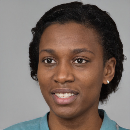Joyful black young-adult female with short  black hair and brown eyes