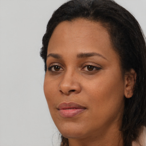 Joyful black young-adult female with long  black hair and brown eyes