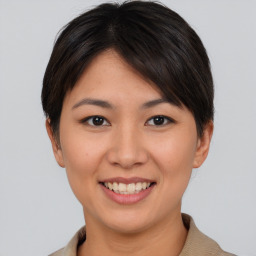 Joyful asian young-adult female with short  brown hair and brown eyes