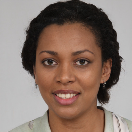 Joyful black young-adult female with short  black hair and brown eyes