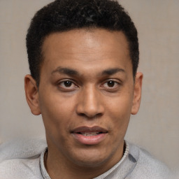 Joyful latino young-adult male with short  brown hair and brown eyes