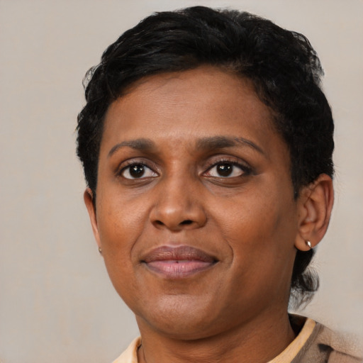 Joyful black adult female with short  brown hair and brown eyes