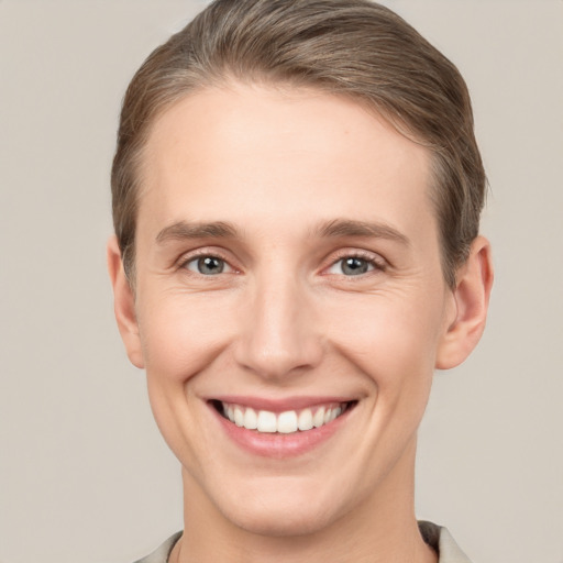 Joyful white young-adult male with short  brown hair and grey eyes