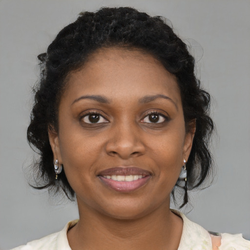 Joyful black young-adult female with medium  brown hair and brown eyes