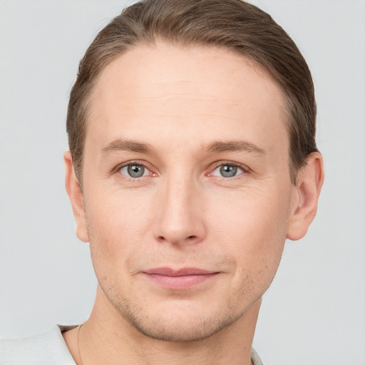 Joyful white young-adult male with short  brown hair and grey eyes