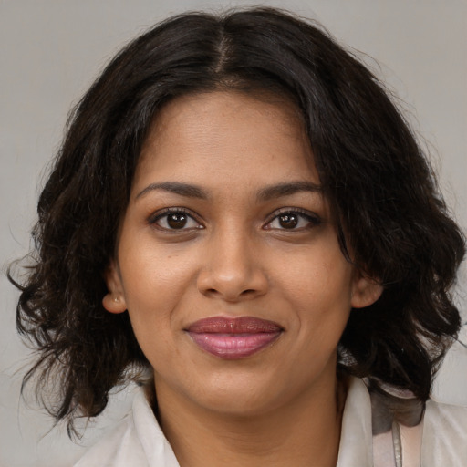 Joyful black young-adult female with medium  brown hair and brown eyes