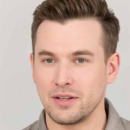 Joyful white young-adult male with short  brown hair and grey eyes