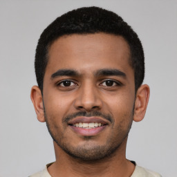 Joyful latino young-adult male with short  black hair and brown eyes