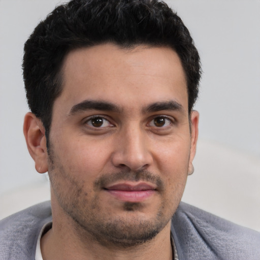 Joyful white young-adult male with short  black hair and brown eyes