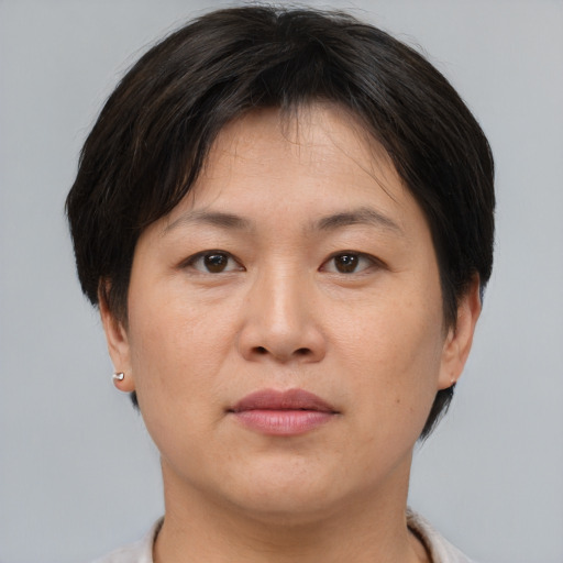 Joyful asian adult female with short  brown hair and brown eyes