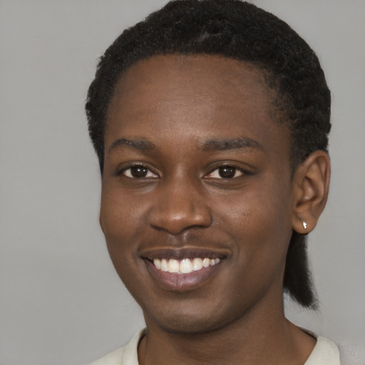 Joyful black young-adult male with short  brown hair and brown eyes