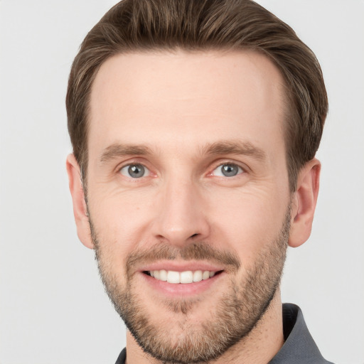 Joyful white young-adult male with short  brown hair and grey eyes