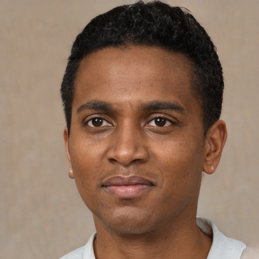 Joyful black young-adult male with short  black hair and brown eyes