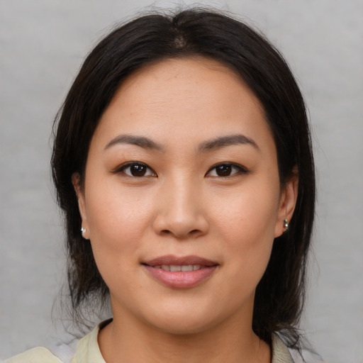 Joyful asian young-adult female with medium  brown hair and brown eyes