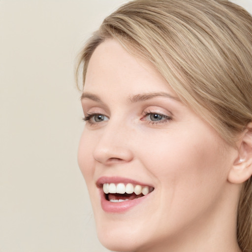 Joyful white young-adult female with long  brown hair and blue eyes