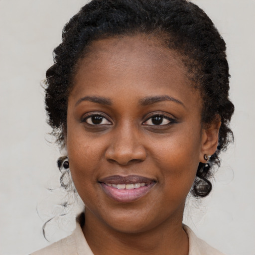 Joyful black young-adult female with medium  brown hair and brown eyes