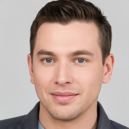 Joyful white young-adult male with short  brown hair and grey eyes