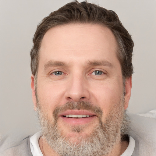 Joyful white adult male with short  brown hair and grey eyes