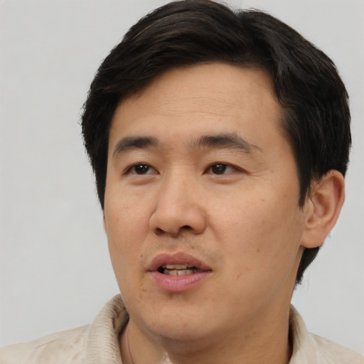 Joyful asian adult male with short  brown hair and brown eyes