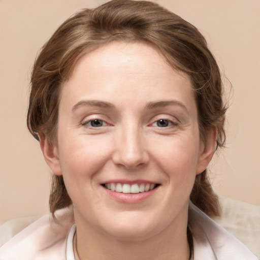 Joyful white young-adult female with medium  brown hair and grey eyes