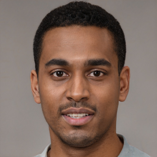 Joyful black young-adult male with short  black hair and brown eyes