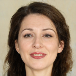 Joyful white adult female with long  brown hair and brown eyes