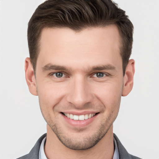 Joyful white young-adult male with short  brown hair and grey eyes