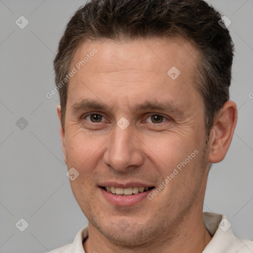 Joyful white adult male with short  brown hair and brown eyes