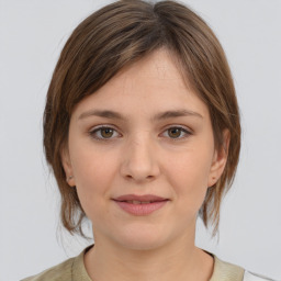 Joyful white young-adult female with medium  brown hair and grey eyes