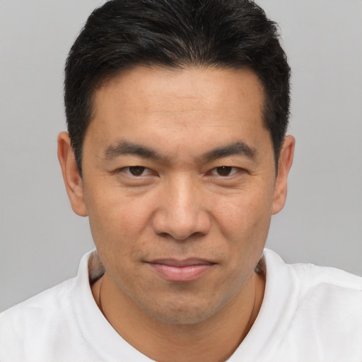 Joyful asian adult male with short  brown hair and brown eyes