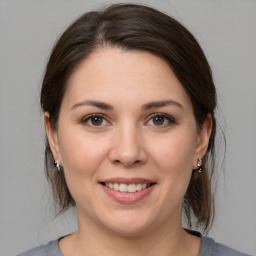 Joyful white young-adult female with medium  brown hair and brown eyes